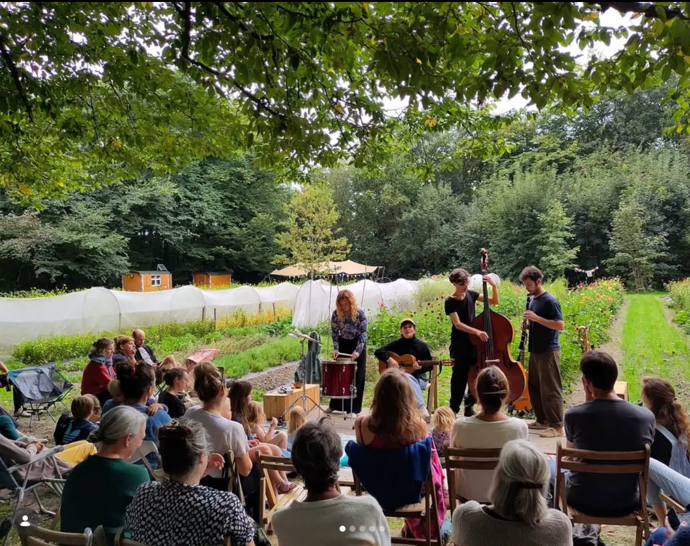 Publiek geniet van een optreden in de bloemenpluktuin